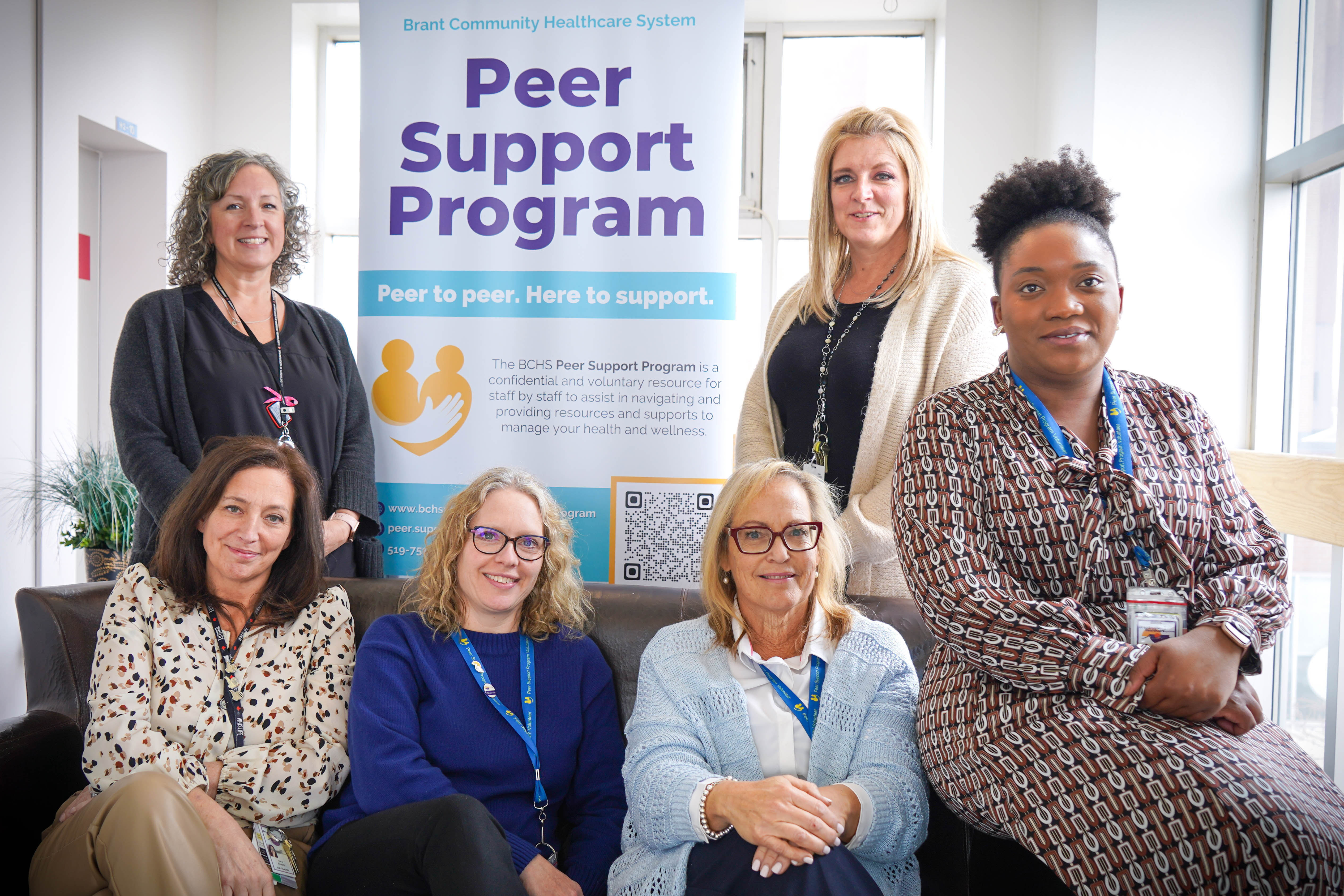 Cindy Hayward-Dale (back right), interim director of Organizational Health, Organizational Development, and Volunteer Engagement for Brantford Community Health System, and Audrey Zheke (front right), peer support and wellness specialist, sit with BCHS Peer Support Program team members