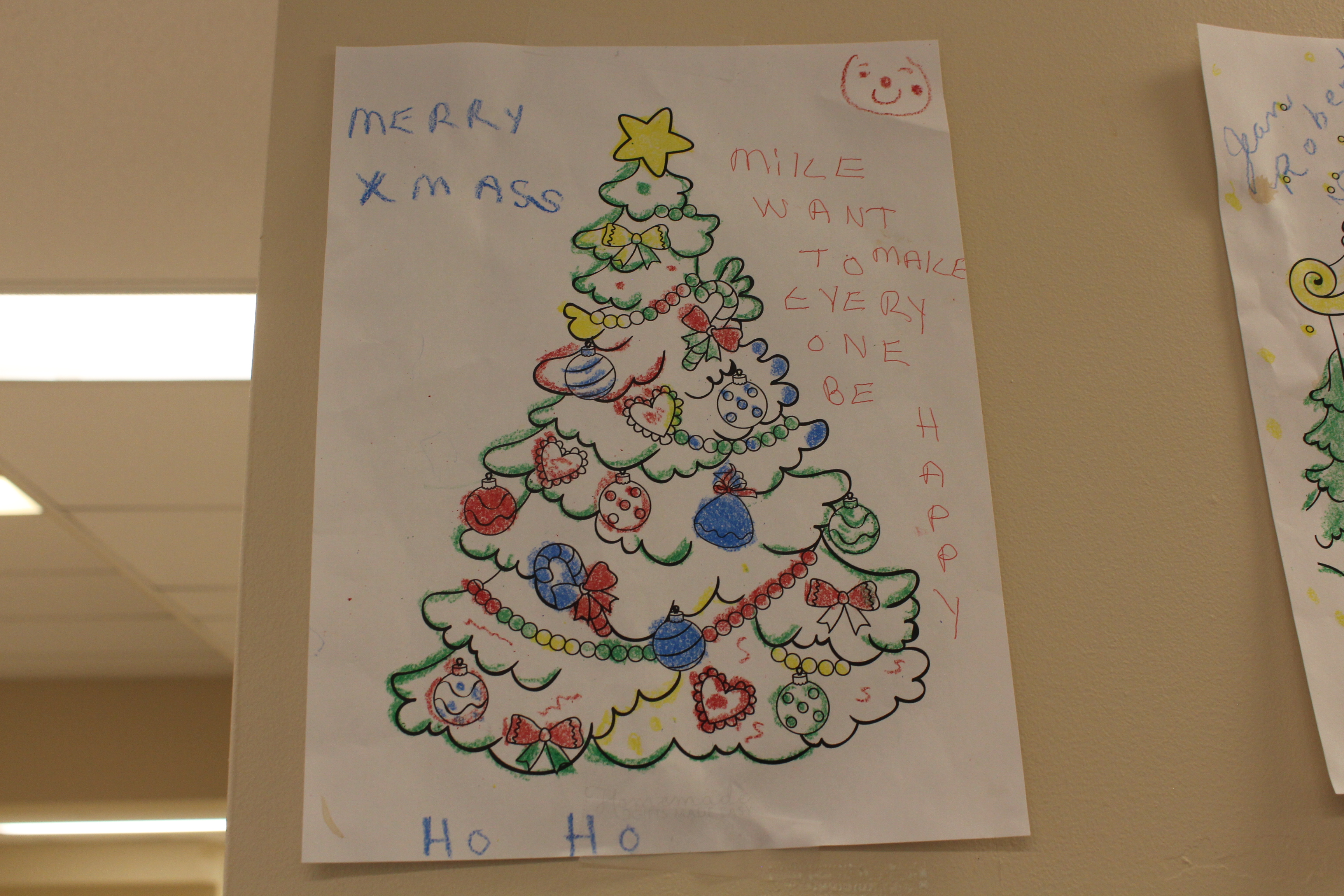 A colouring picture of a Christmas tree. It reads, "Merry X-Mas. Mike want to make everyone be happy. Ho Ho."