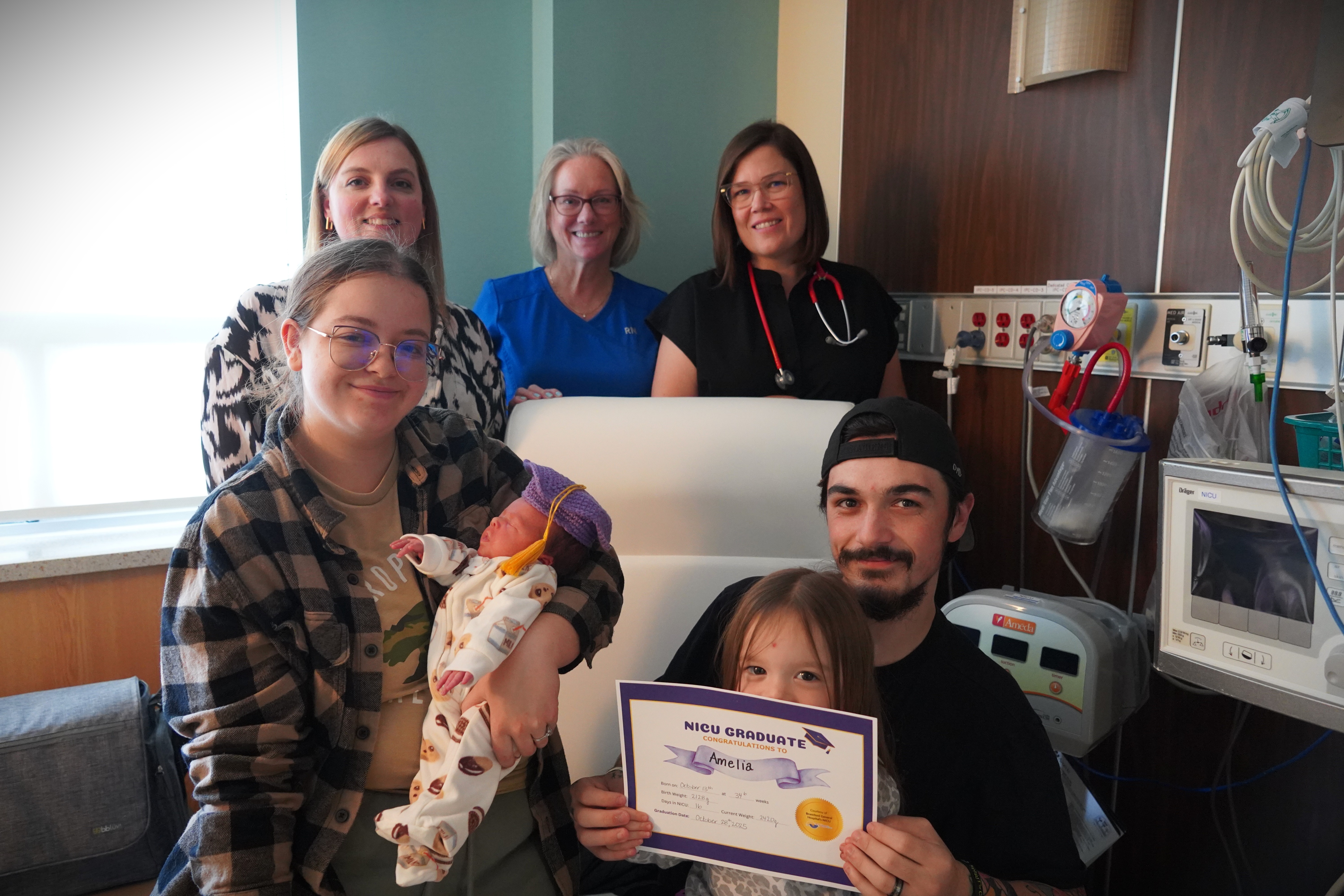 Front row from left to right: Jackie (mom), Amelia (NICU graduate), Noelle (big sister), and Zack (dad). Back row from left to right: Amy Griesser, Liz Almeida, Dr. Dooley