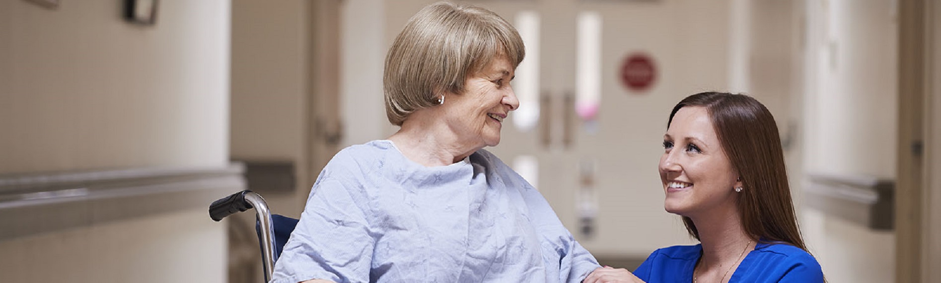 Nurse bending down to talk with patient