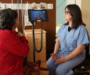 A patient and an RN using Lingotec translation services while interacting.
